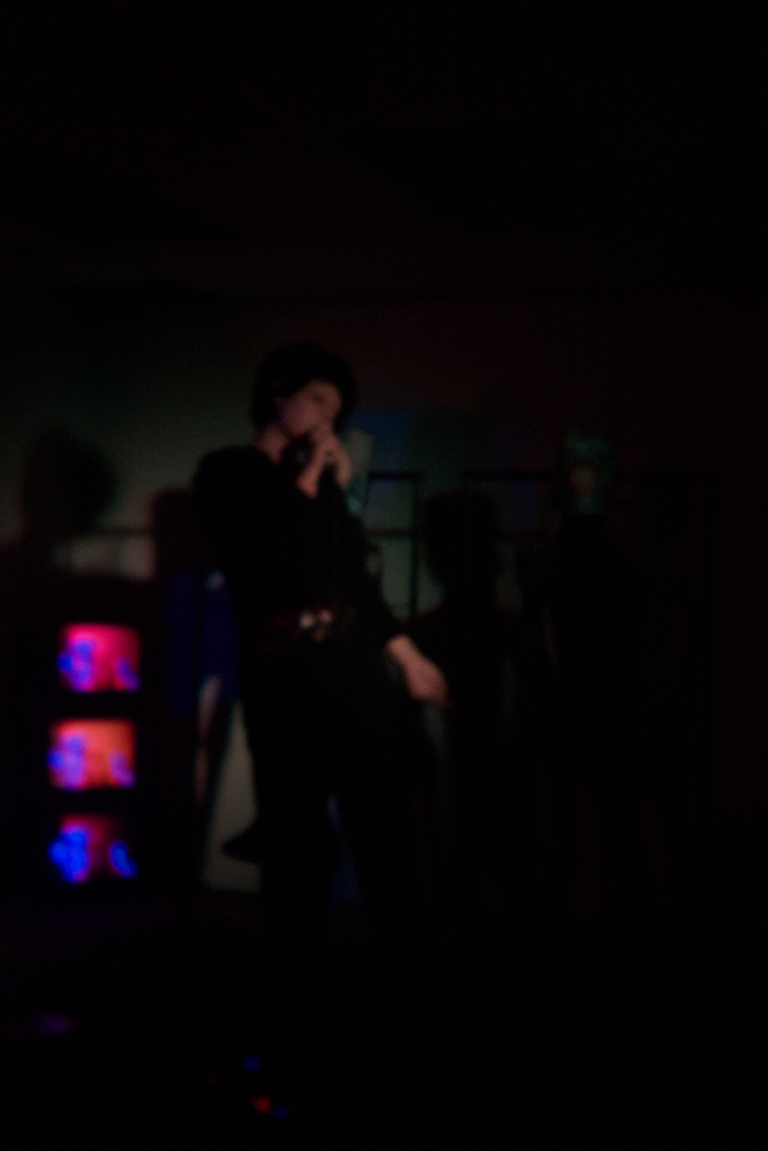2025 — Vocalist beside glowing CRT screens